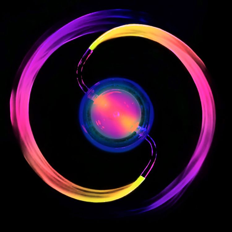 Eine künstlerische Darstellung zeigt farbige, geschwungene Wasserstrahlen, die von einem zentralen Punkt ausgehen. Die Strahlen sind in fluoreszierenden Farbtönen wie Pink, Gelb und Blau gefärbt, auf schwarzem Hintergrund.