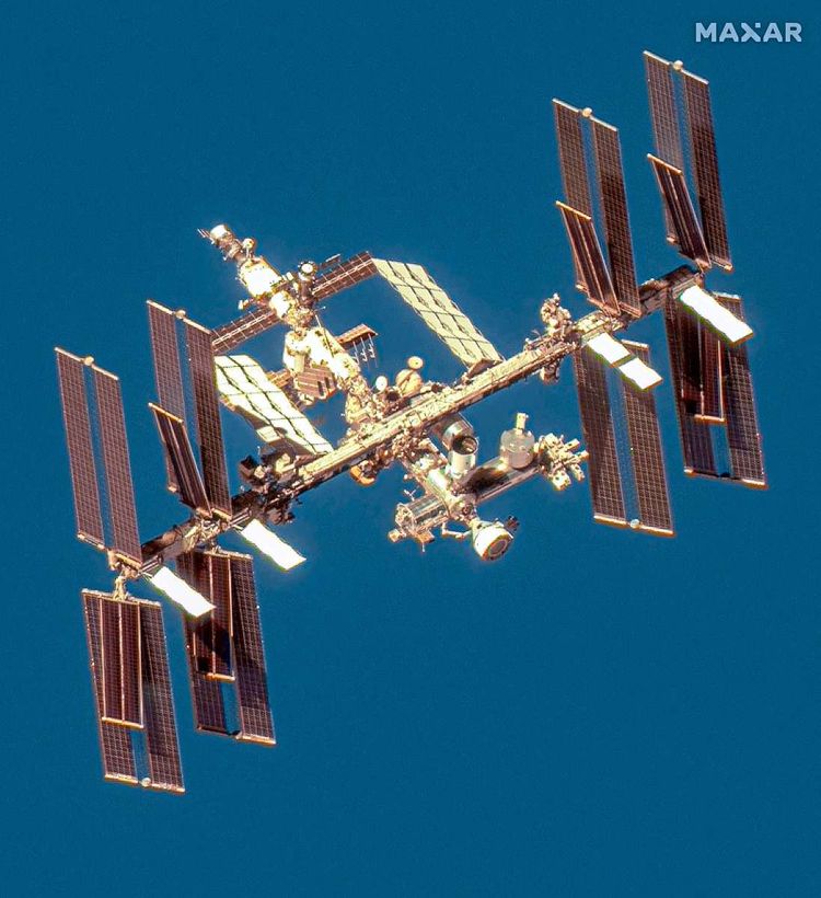 Die internationale Raumstation mit dem Blau des Ozeans im Hintergrund.