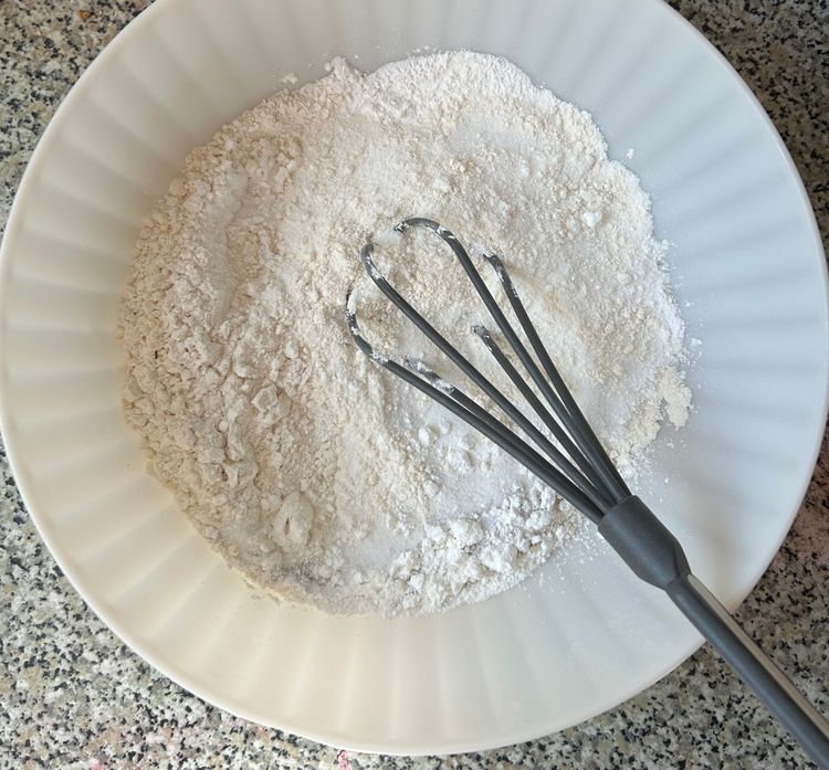 Die trockenen Zutaten (Mehl, Zucker, Vanillezucker, Backpulver, Maisstärke) in eine Schüssel geben und mit dem Schneebesen mischen.