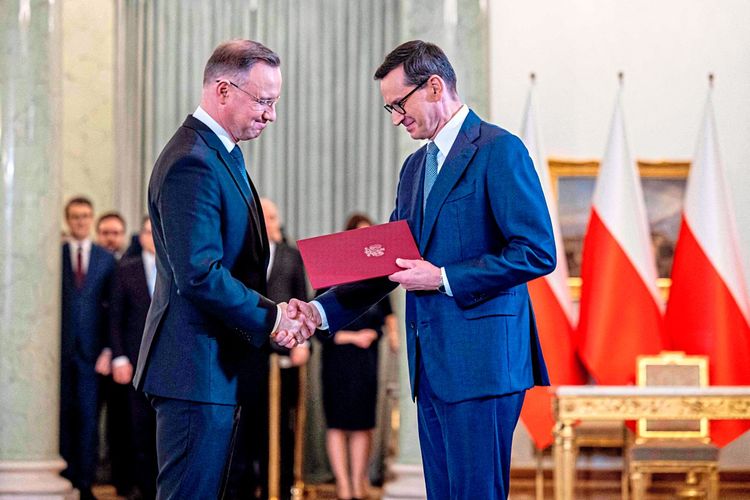 Präsident Andrzej Duda überreicht dem amtierenden Premier Mateusz Morawiecki die Ernennungsurkunde.