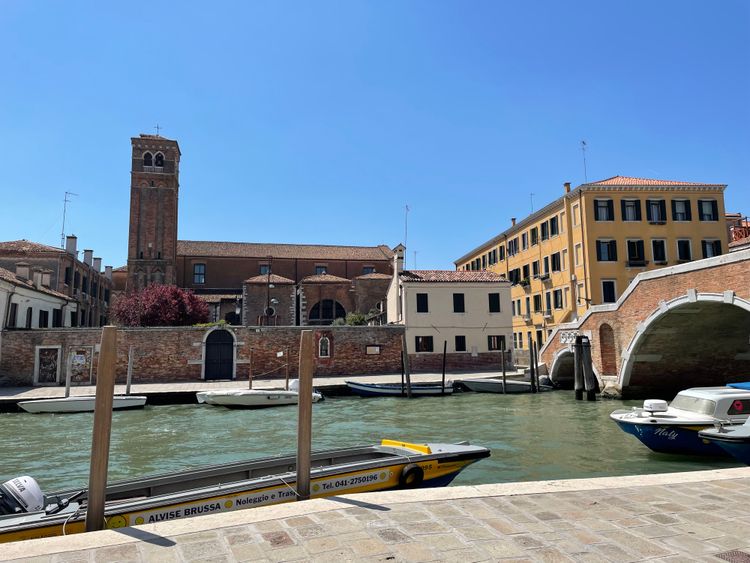 Kanal in Venedig mit Gebäuden und Kirche im Hintergrund