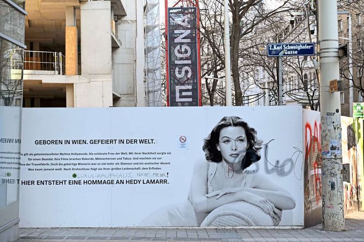 Ein Plakat mit einem Foto von Hedy Lamarr, dahinter die Baustelle fürs gleichnamige Signa-Projekt