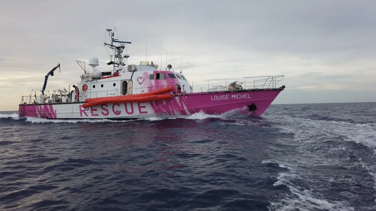 Zu sehen ist ein Rettungsboot mit Namen Louise Michel am Wasser.