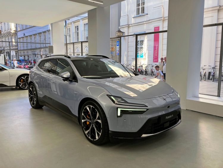 Grauer Polestar 4 SUV während der Österreich-Premiere im Polestar-Space in Wien, mit moderner Fassade und Straßenszene im Hintergrund.