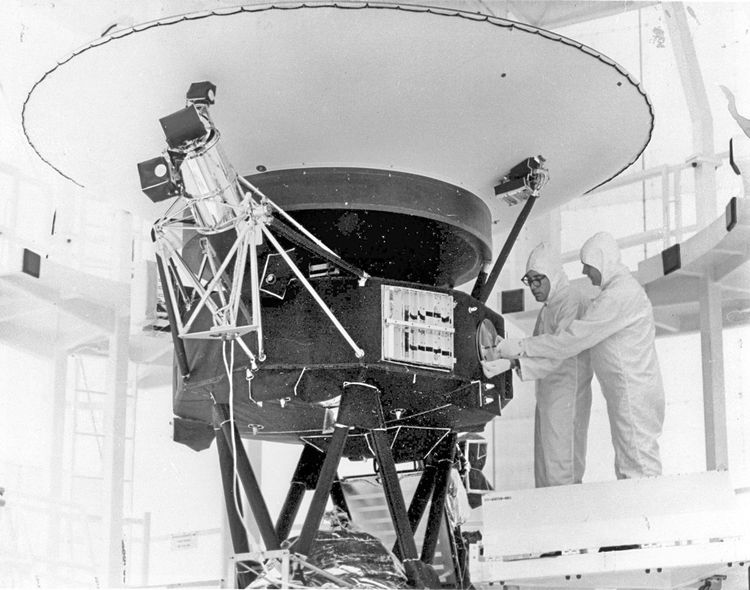 Eine Schwarz-Weiß-Aufnahme vom 4. August 1977 zeigt zwei Techniker in weißen Vollköperanzügen bei der Montage der Audiodatei 