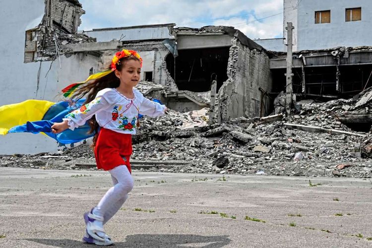 Kind, Ukraine-Flagge, zerstörtes Kunstzentrum