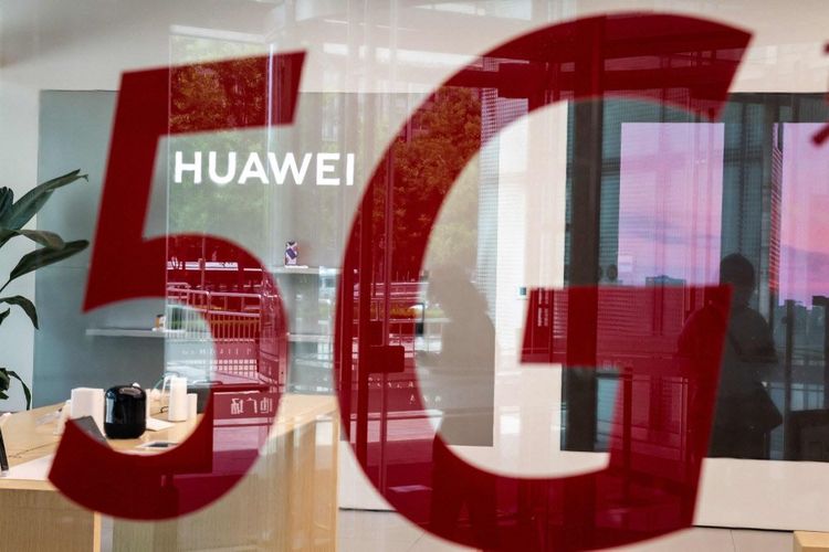 Eine Glasscheibe mit 5G-Schriftzug reflektiert den Firmennamen Huawei