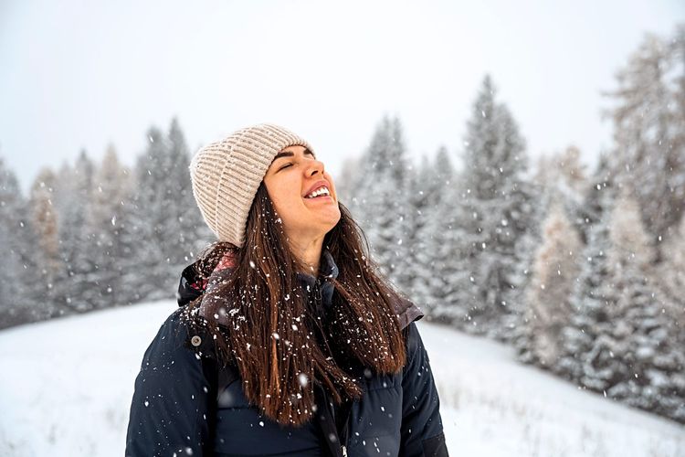 Frau lacht im Schnee.