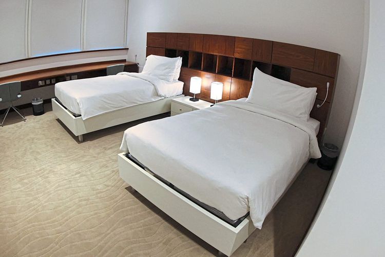 Zwei leere Betten in einem Hotelzimmer.
