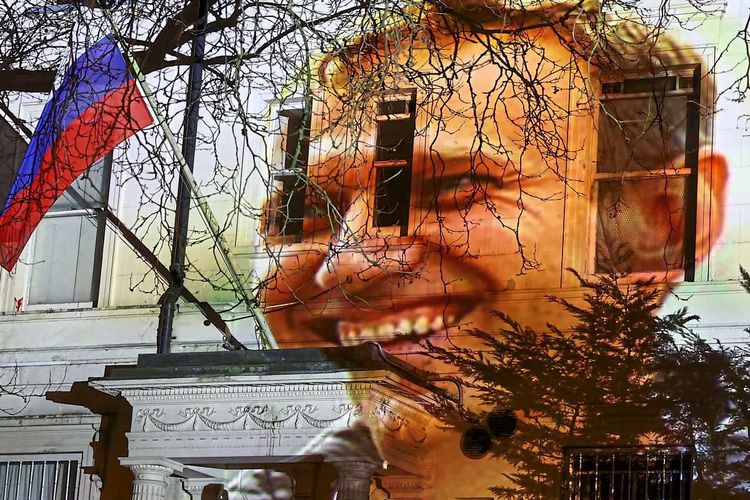 Nawalnys Gesicht auf Gebäude. Mittendrin weht russische Flagge.