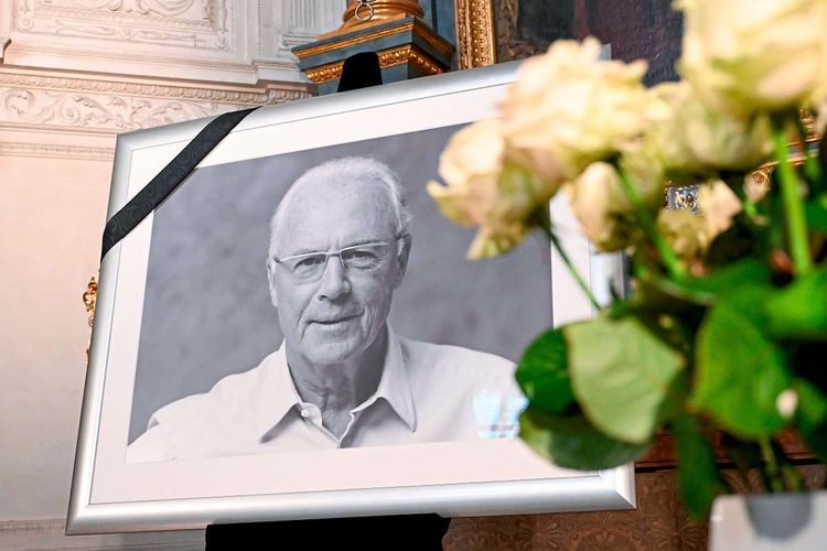 Ein Porträt von Franz Beckenbauer ist neben einem Strauß weißer Rosen in der Hofkapelle der Residenz zu sehen