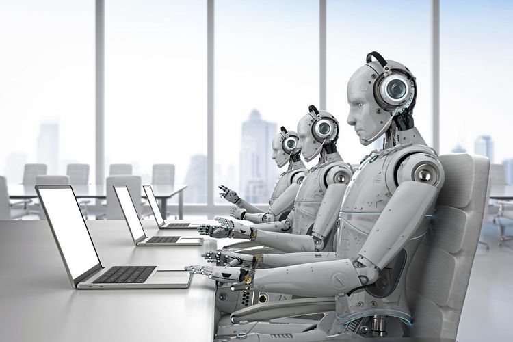 Drei humanoide Roboter arbeiten nebeneinander an einem Laptop mit Headset