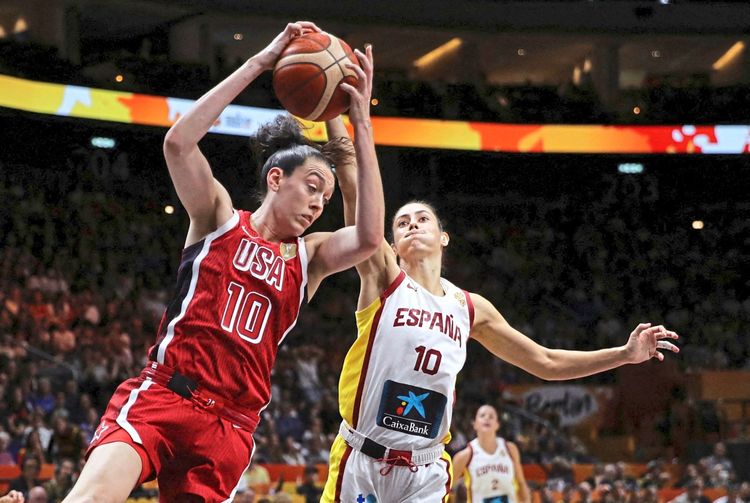 Zwei Basketballspielerinnen kämpfen während des FIBA Basketball Women's World Cup Halbfinals zwischen Spanien und den USA um den Ball. Spielerin der USA (im roten Trikot) springt, während eine spanische Spielerin (im weißen Trikot) versucht, den Ball zu blocken.