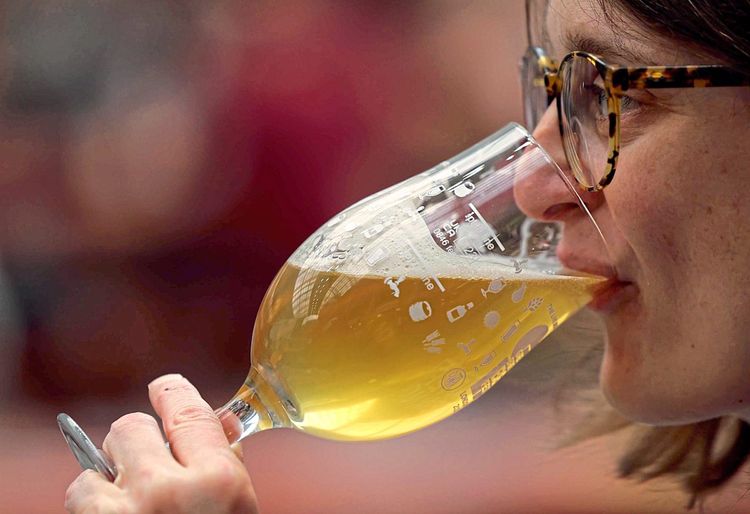 Eine Frau trinkt Bier aus einem Glas