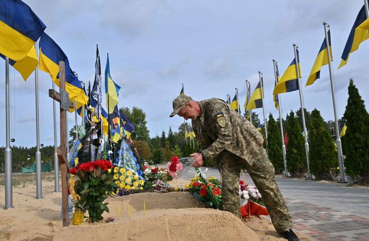 Soldat vor Gräbern ukrainischer Kameraden