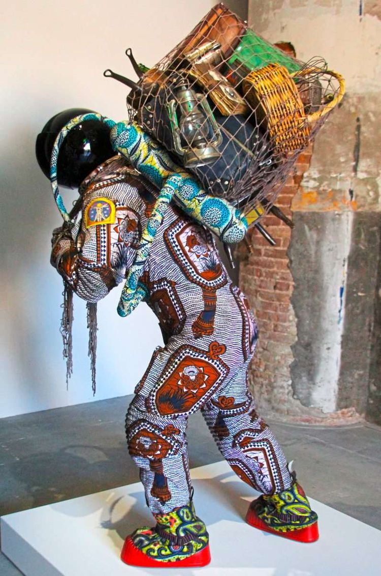 Der britisch-nigerianische Künstler Yinka Shonibare zeigt einen Astronauten im bunt geschnörkelten Textilanzug mit antiquierten Reiseutensilien.