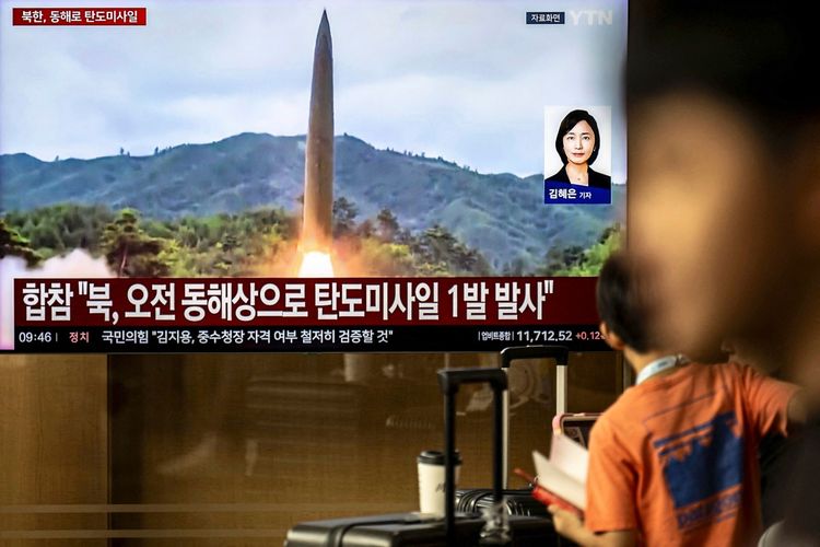 Eine Nachrichtensendung zeigt Filmmaterial eines nordkoreanischen Raketenstarts auf einem Bildschirm am Seoul Station in Seoul am 3. Oktober 2026. Ein roter Infobalken informiert über den Raketenabschuss. Im Vordergrund ist eine Person unscharf zu sehen.
