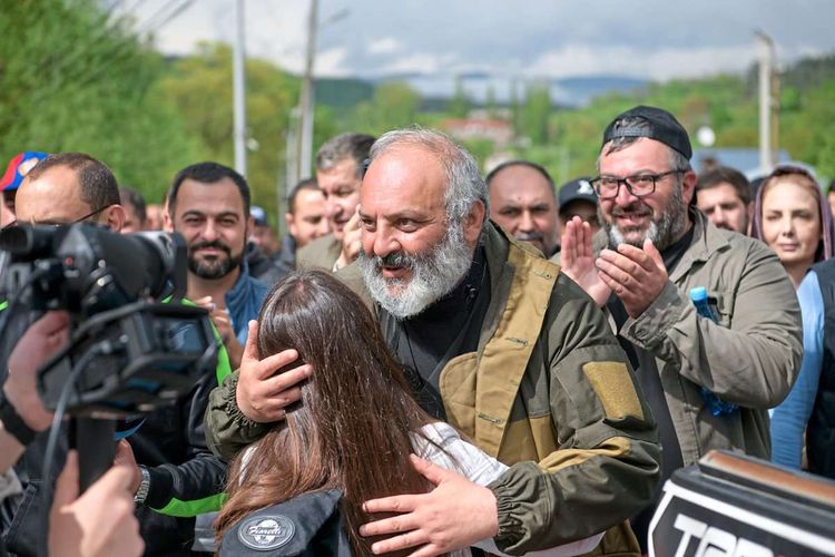 Galstanjan umarmt eine Frau, Protestteilnehmer klatschen im Hintergrund