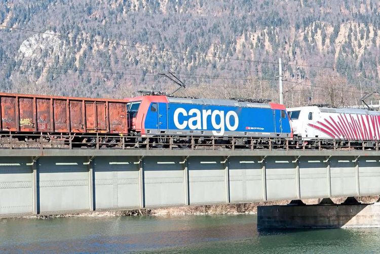 Zwei Lokomotiven ziehen Güterwaggons über eine Eisenbahnbrücke auf der Strecke Innsbruck-München.