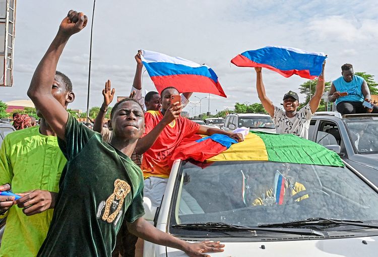 Junta-Anhänger schwenken in Niamey nigrische und russische Fahnen, in Anspielung an mögliche Unterstützung durch Wagner-Söldner.