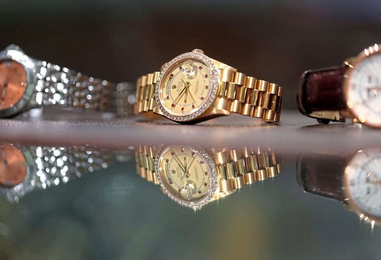 Mehrere Rolex-Uhren auf einem Glastisch. 