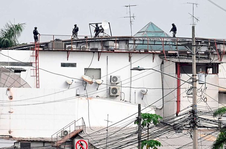 Maskierte Soldaten auf dem Dach eine Gebäudes, auf dem mehrere Satellitenantennen montiert sind.