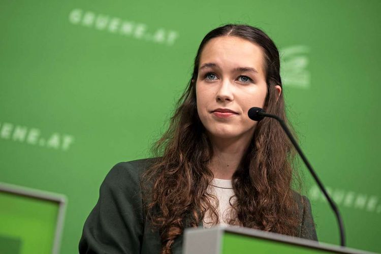Lena Schilling bei einer Pressekonferenz, im Hintergrund Logo der Grünen 