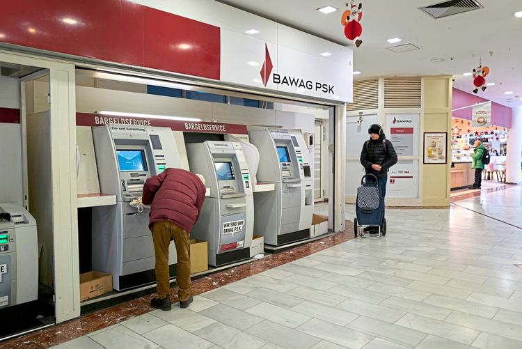 Mann in roter Jacke am Bankomaten