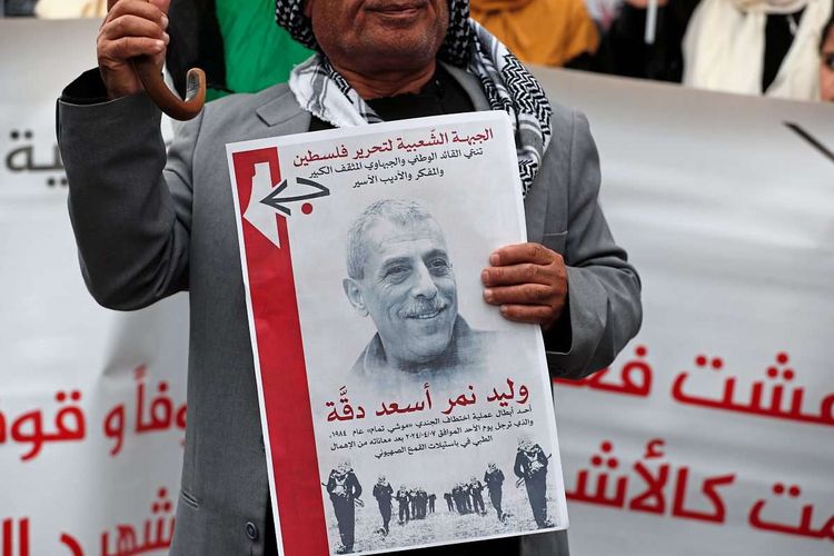Ein Demonstrant mit einem Bild von Walid Daqqah.