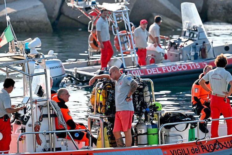 Italienische Feuerwehrtaucher während der Bergungsarbeiten auf zwei Booten.