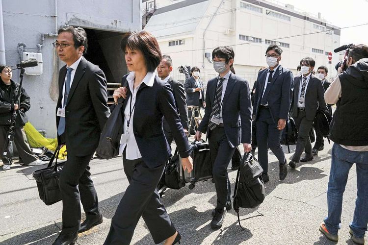 Beamte des japanischen Gesundheitsministeriums am Weg zur Inspektion.
