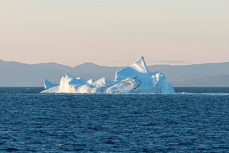 Ein Eisberg vor den Bergen der grönländischen Küste.