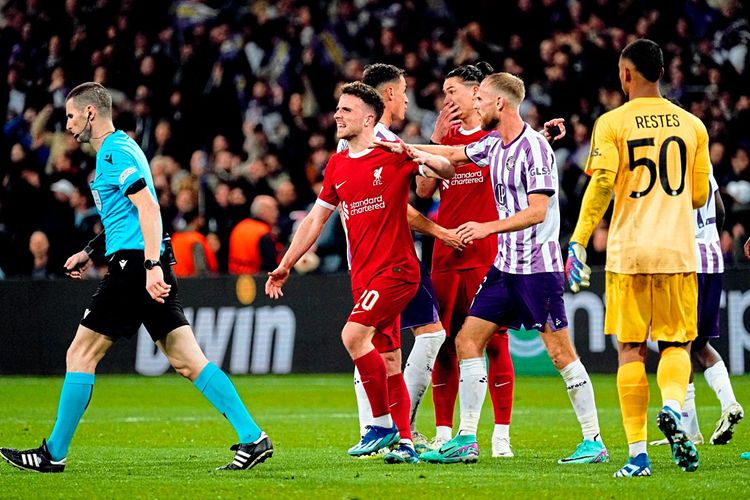 Liverpool- und Toulouse-Spieler diskutieren, während der Schiedsrichter zum TV-Monitor geht.