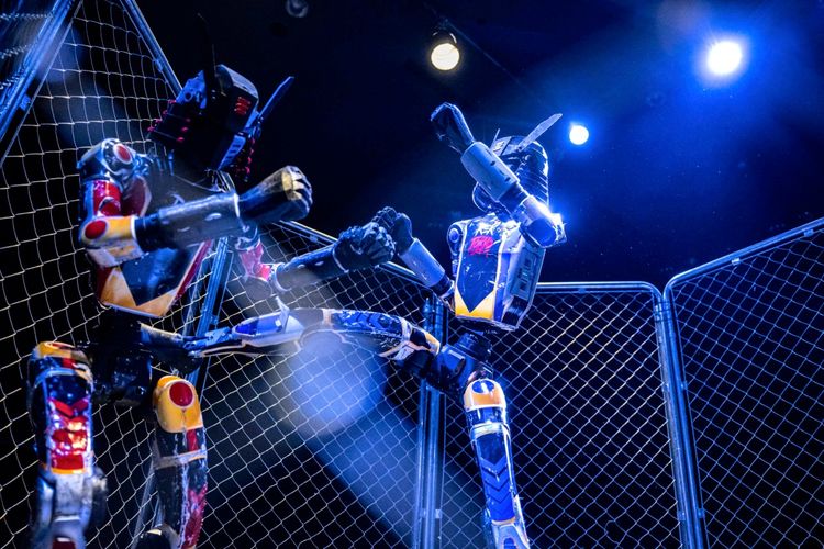 Zwei humanoide Roboter kämpfen in einem Käfig unter blauer Beleuchtung während des Events „Rek Tokyo 2026“ im Stadtteil Akihabara in Tokio.