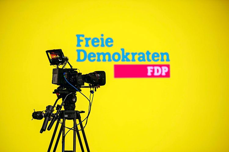 Video-Kamera auf Stativ vor dem Logo der Freien Demokraten