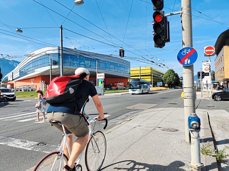Ein Radfahrer auf der Innsbrucker Bundesstraße vor einer roten Ampel an der der Radweg abrupt endet.