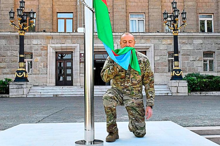 Aserbaidschans Präsident Ilham Alijew küsst in Stepanakert die Flagge seines Landes.
