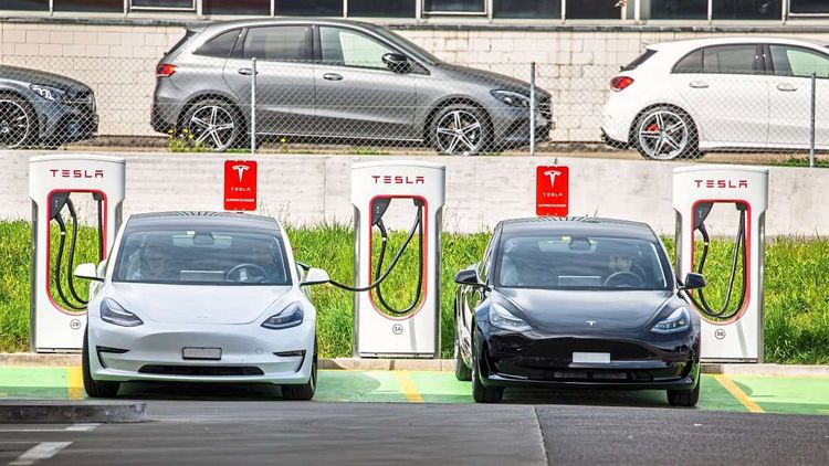 Das Bild zeigt zwei Tesla Model 3 Fahrzeuge bei einem Tesla Supercharger.