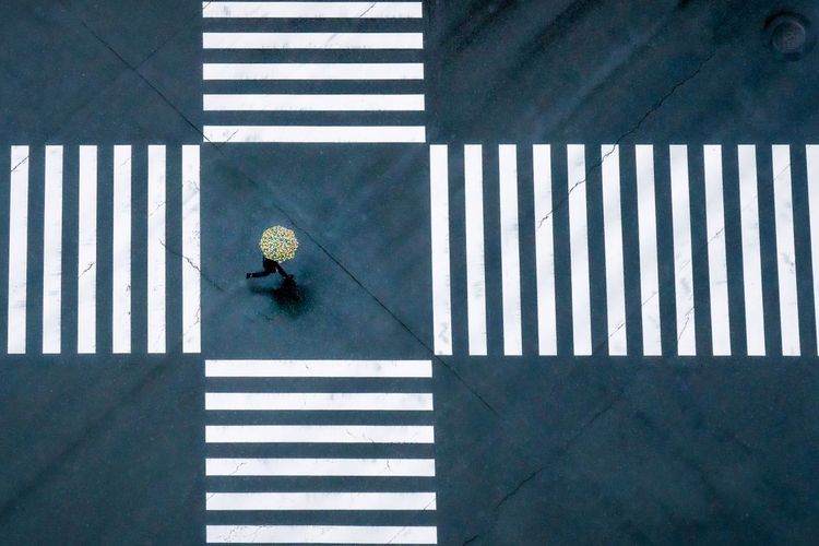 Ein einsamer Fußgänger eilt über eine große Kreuzung in Tokio, bevor die Ampel umspringt. In Tokio, einer Metropole mit 13 Millionen Einwohnern, gibt es viele große Kreuzungen, aber es ist selten, dass eine so leer ist.