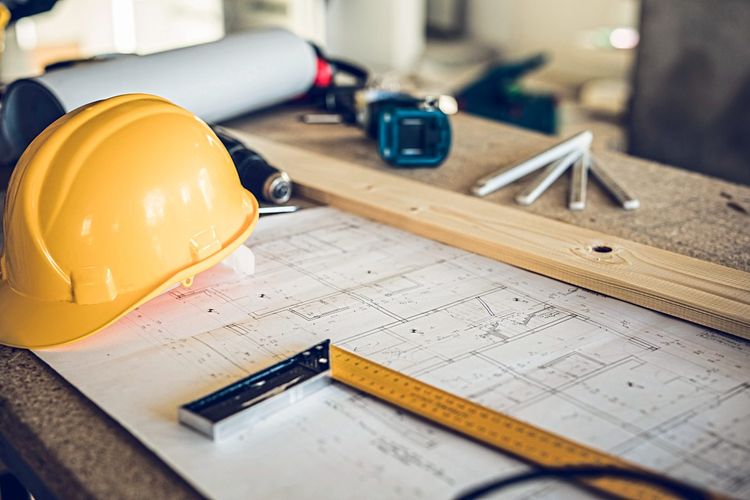 Bauplan, Lineal und Helm auf Baustelle