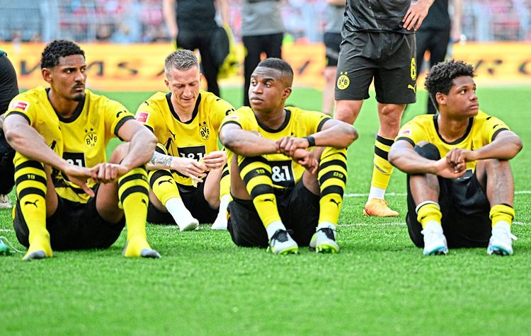 Dortmund-Profis sitzen am Spielfeld.