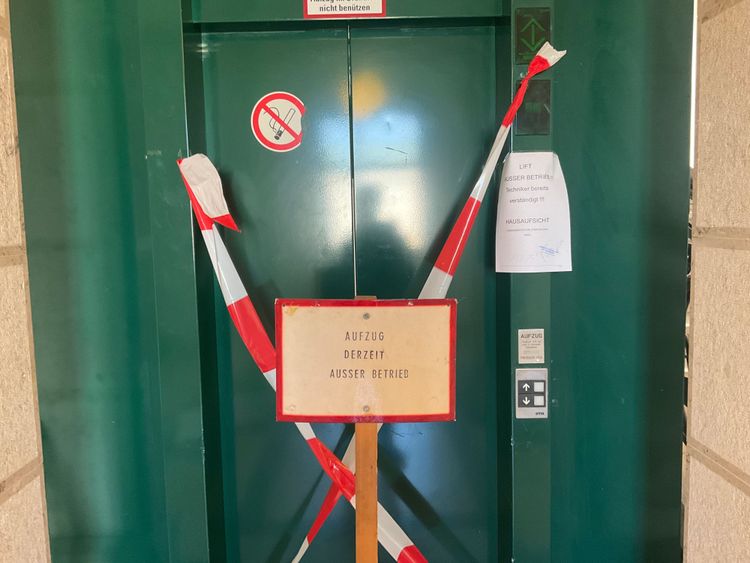Ein Lift im Landesgericht Wien ist mit rot-weißem Absperrband verklebt, davor teilt eine Tafel mit, dass der Aufzug derzeit außer Betrieb sei.