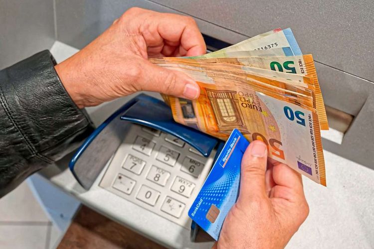 Ein Mann behebt Bargeld aus einem Bankomaten