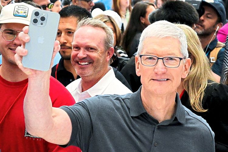 Apple CEO Tim Cook hält eine iPhone 15 Pro in die Kamera