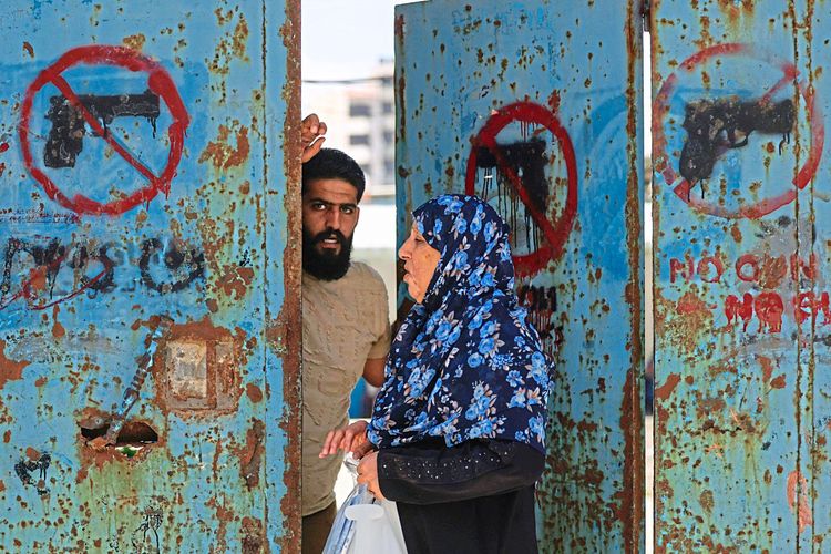 Zwei Palästinenser - eine Frau und ein Mann - stehen in einer Tür.