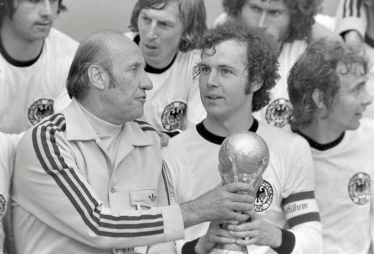 Kapitän Franz Beckenbauer hält den Pokal für den WM-Titel 1974 mit Trainer Helmut Schön.