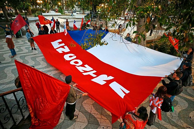 Menschen halten eine riesige Chile-Fahne