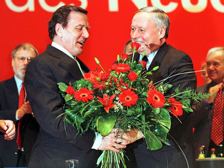 Oskar Lafontaine überreicht Gerhard Schröder Blumen.