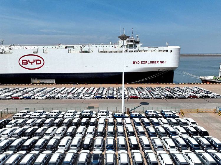 Viele BYD Autos in einem Hafen vor einem Schiff