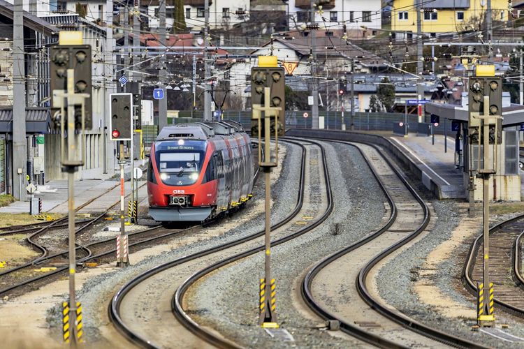 Bahnhof Matrei am Brenner mit einem roten Regionalzug der ÖBB auf Gleis 1. Die Fahrtzielanzeige zeigt 